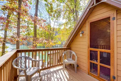a cabin with two chairs on a deck at Hocking Hills Lake Gem with Hot Tub, Dock, 100 Acres in Hamden