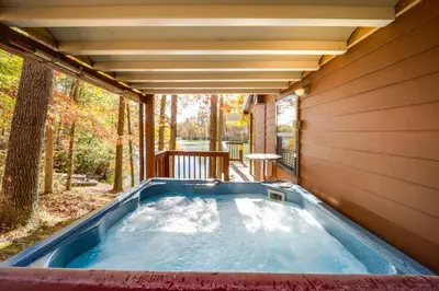 a jacuzzi tub in the backyard of a house at Hocking Hills Lake Gem with Hot Tub, Dock, 100 Acres in Hamden