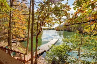a wooden bridge over a river with trees at Hocking Hills Lake Gem with Hot Tub, Dock, 100 Acres in Hamden