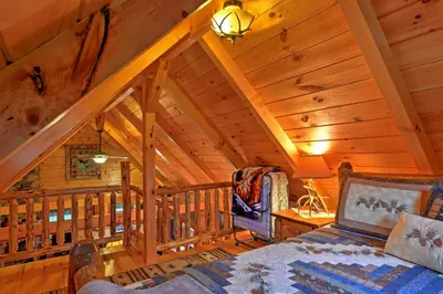 a bedroom with a bed in a cabin with wooden ceilings at Rustic Dundee Log Cabin with Hot Tub and Forest Views! in Dundee
