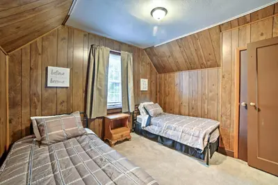 two beds in a room with wooden walls at Burgettstown Home - 7 Mi to KeyBank Pavilion in Burgettstown