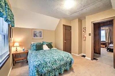 a bedroom with a bed with a blue comforter at Burgettstown Home - 7 Mi to KeyBank Pavilion in Burgettstown