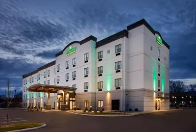 a large white building with green lights on it at Wingate by Wyndham Hurricane WV in Hurricane