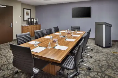 a conference room with a large wooden table and chairs at Wingate by Wyndham Hurricane WV in Hurricane