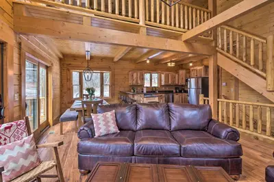 a living room with a leather couch in a log cabin at Family-Friendly Warsaw Cabin with Deck and Fireplace! in Warsaw
