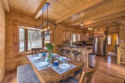 a dining room and kitchen in a log cabin at Family-Friendly Warsaw Cabin with Deck and Fireplace! in Warsaw