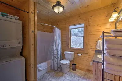 a bathroom with a toilet and a shower and a window at Family-Friendly Warsaw Cabin with Deck and Fireplace! in Warsaw
