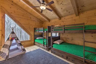 a bedroom with three bunk beds in a log cabin at Family-Friendly Warsaw Cabin with Deck and Fireplace! in Warsaw