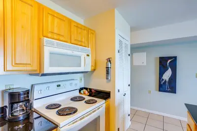 a kitchen with a white stove and a microwave at Waterfront Middle Bass Condo with Pool Access! in Put-in-Bay