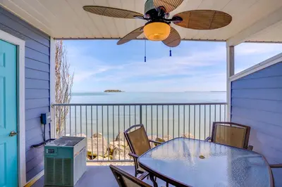 a table and chairs on a balcony with a ceiling fan at Waterfront Middle Bass Condo with Pool Access! in Put-in-Bay