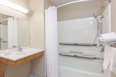 a bathroom with a tub and a sink and a shower at Super 8 by Wyndham Dunbar/Charleston Area in Charleston