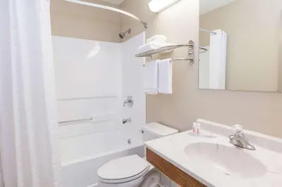 a bathroom with a sink and a toilet and a tub at Super 8 by Wyndham Dunbar/Charleston Area in Charleston