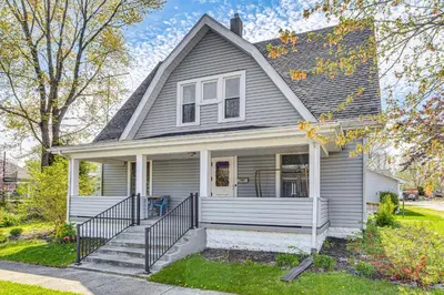 a gray house with a porch and stairs at The Junction Victorian Home in Quaint Fortville! in Fortville