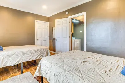 a bedroom with two beds and a door to a bathroom at The Junction Victorian Home in Quaint Fortville! in Fortville