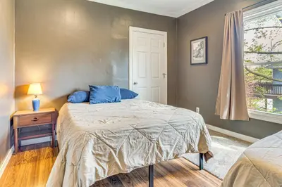 a bedroom with a bed with blue pillows and a window at The Junction Victorian Home in Quaint Fortville! in Fortville