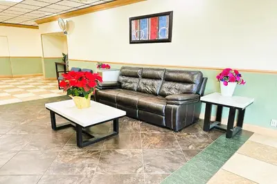 a waiting room with a leather couch and two tables at Buckeye Inn Express in Columbus