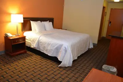 a hotel room with a bed and a telephone at Buckeye Inn Express in Columbus