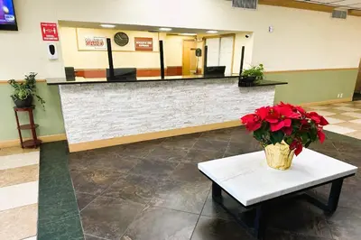 a lobby with a waiting area with red flowers on a table at Buckeye Inn Express in Columbus