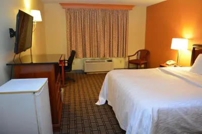 a hotel room with a bed and a television at Buckeye Inn Express in Columbus