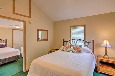 a bedroom with a large white bed and a window at Home with Lake-View Deck by Camp Perry and Magee Marsh in Port Clinton