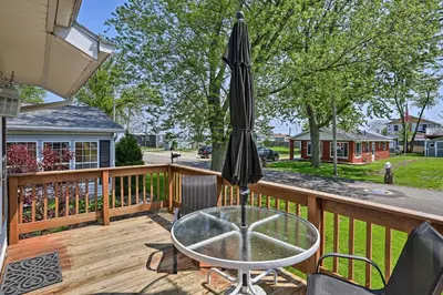 a patio with a table and an umbrella on a deck at Home with Lake-View Deck by Camp Perry and Magee Marsh in Port Clinton
