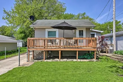 a house with a wooden deck with an umbrella at Home with Lake-View Deck by Camp Perry and Magee Marsh in Port Clinton