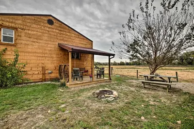 a wooden cabin with a picnic table and a bench at The Bovard Lodge Rustic Cabin Near Ohio River! in Florence
