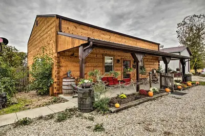 a small wooden house with a porch at The Bovard Lodge Rustic Cabin Near Ohio River! in Florence