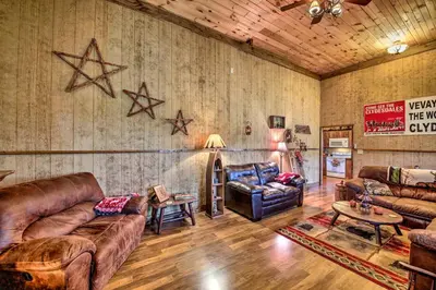 a living room with leather couches and a table at The Bovard Lodge Rustic Cabin Near Ohio River! in Florence