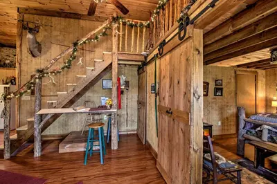 a room with wooden walls and stairs in a barn at The Bovard Lodge Rustic Cabin Near Ohio River! in Florence