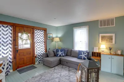 a living room with a couch in front of a door at Spacious Lakeside Cottage - 2 Miles to Marblehead! in Lakeside