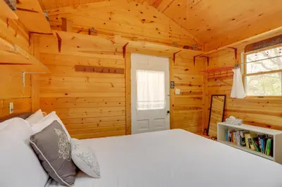 a bedroom with a bed in a log cabin at Spacious Lakeside Cottage - 2 Miles to Marblehead! in Lakeside