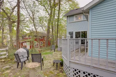 a blue house with a deck with chairs and a table at Spacious Lakeside Cottage - 2 Miles to Marblehead! in Lakeside
