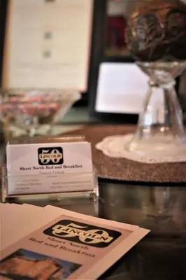 a table with a card and a wine glass at 50 Lincoln Short North Bed & Breakfast in Columbus