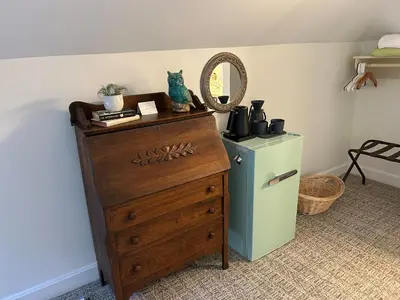 a dresser with a mirror on top of it next to a refrigerator at 50 Lincoln Short North Bed & Breakfast in Columbus