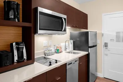 a kitchen with a sink and a refrigerator at TownePlace Suites Cincinnati Fairfield in Fairfield