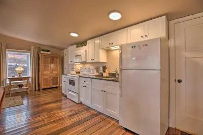 a kitchen with white cabinets and a refrigerator at Chic Main Street Retreat Less Than 7 Mi to KY Horse Park! in Georgetown