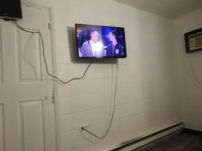 a television on a wall in a room at LAWRENCEBURG MOTEL in Greendale