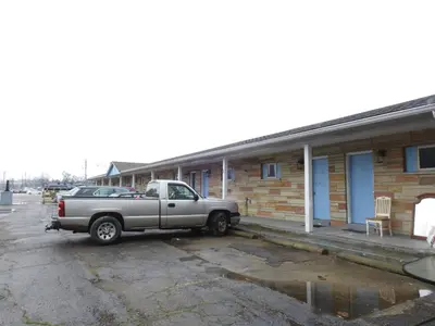 a truck parked in a parking lot in front of a building at LAWRENCEBURG MOTEL in Greendale