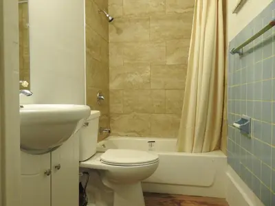 a bathroom with a toilet and a sink and a tub at LAWRENCEBURG MOTEL in Greendale