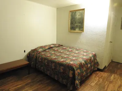 a small bedroom with a bed and a table at LAWRENCEBURG MOTEL in Greendale