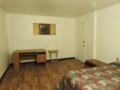 a hotel room with a bed and a desk and a table at LAWRENCEBURG MOTEL in Greendale
