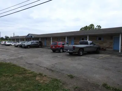 a row of cars parked in front of a building at LAWRENCEBURG MOTEL in Greendale