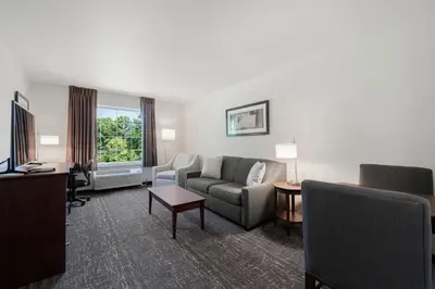 a living room with a couch and a chair at Cobblestone Hotel & Suites - Urbana in Urbana