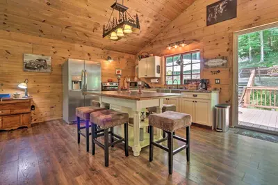 a kitchen with a counter and stools in a cabin at Butler Cabin on 19 Acres with Hot Tub and Fire Pit! in Butler