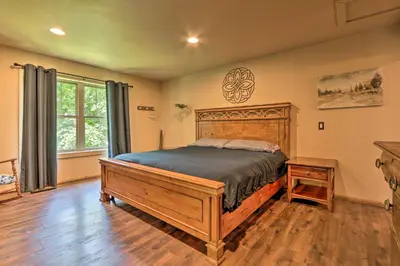 a bedroom with a wooden bed in a room at Butler Cabin on 19 Acres with Hot Tub and Fire Pit! in Butler