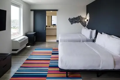 a hotel room with two beds and a colorful rug at Aloft Columbus in Columbus