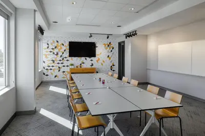 a conference room with a large white table and chairs at Aloft Columbus in Columbus