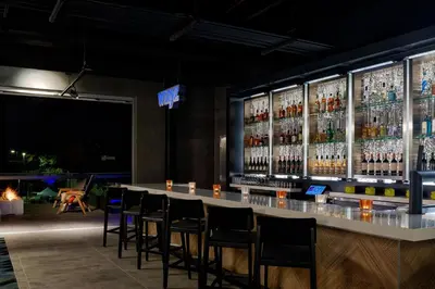 a bar in a restaurant with bar stools at Aloft Columbus in Columbus