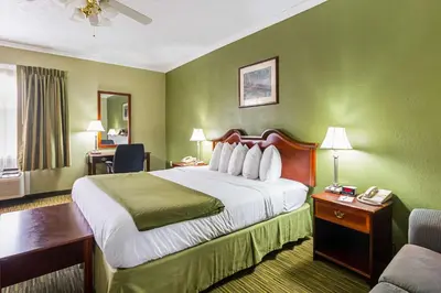 a hotel room with a large bed and a desk at Quality Inn Weston in Weston
